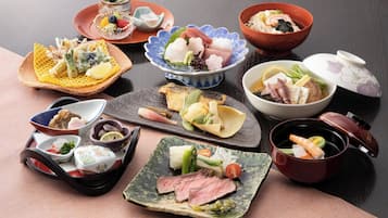 A variety of dishes on a table, including sushi, sashimi, and other Japanese cuisine.
