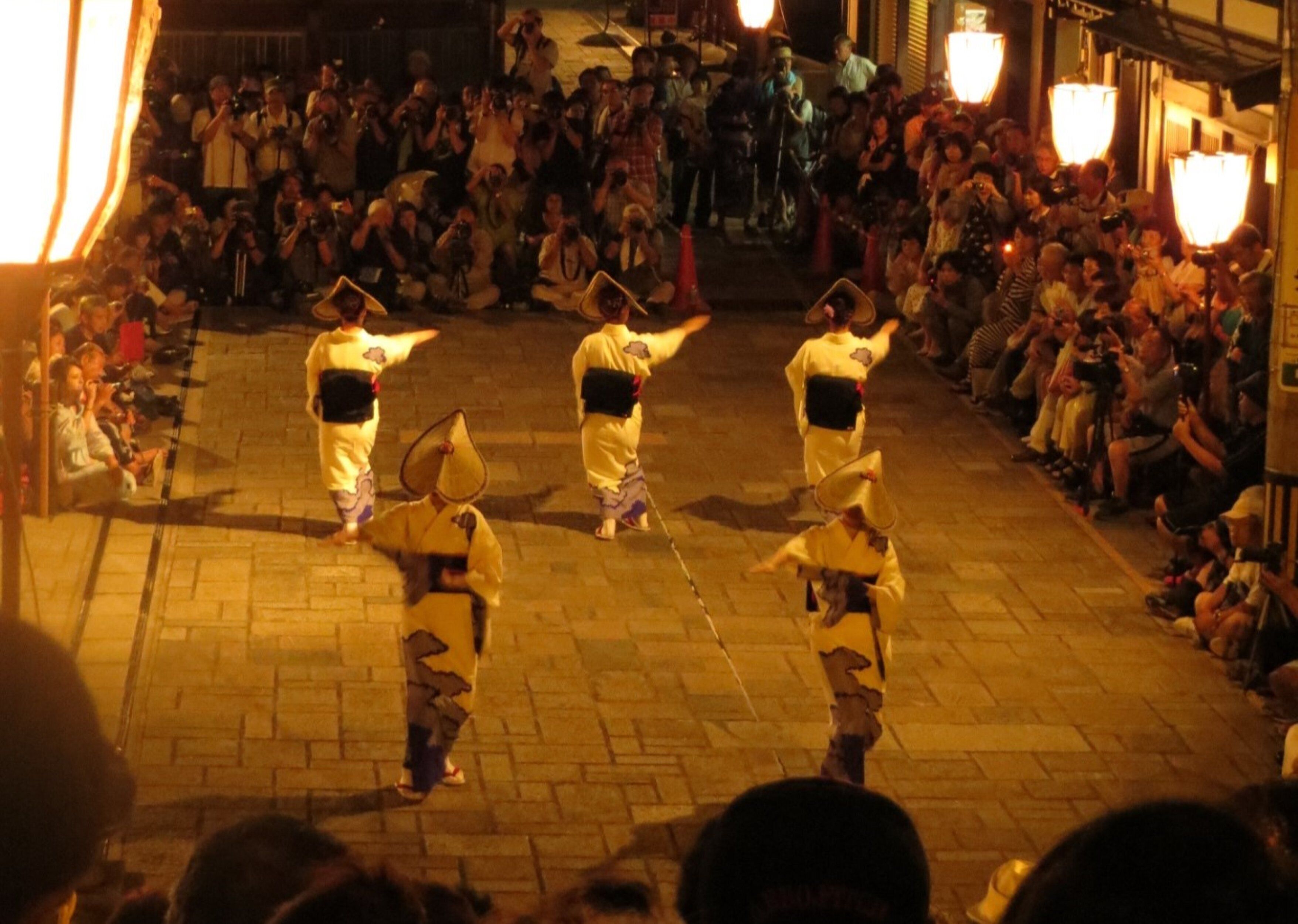 A group of performers in traditional attire on a street.