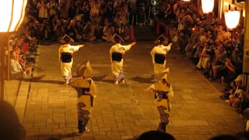 A group of performers in traditional attire on a street.