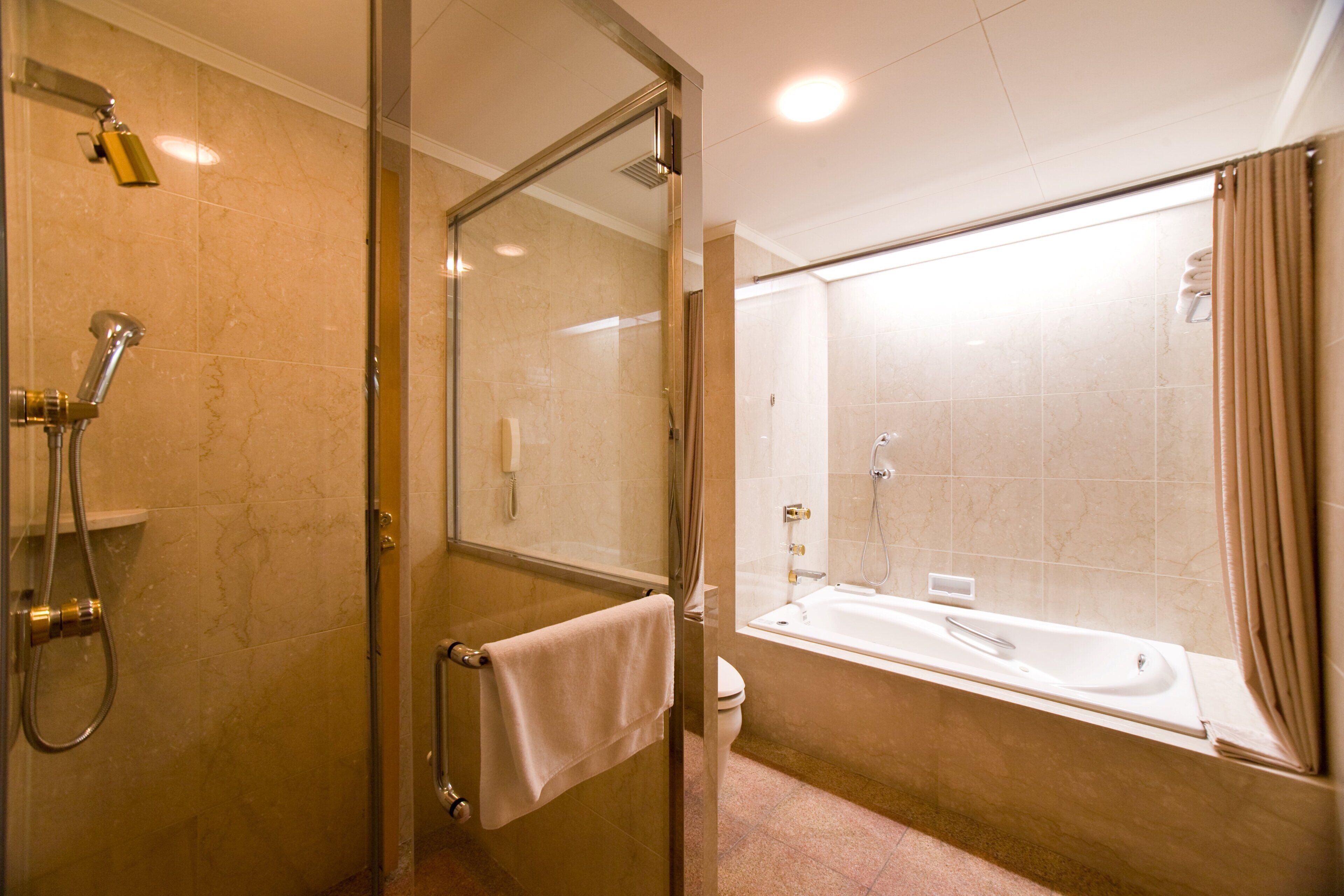 Une salle de bain avec une douche à parois de verre, des toilettes et une baignoire.