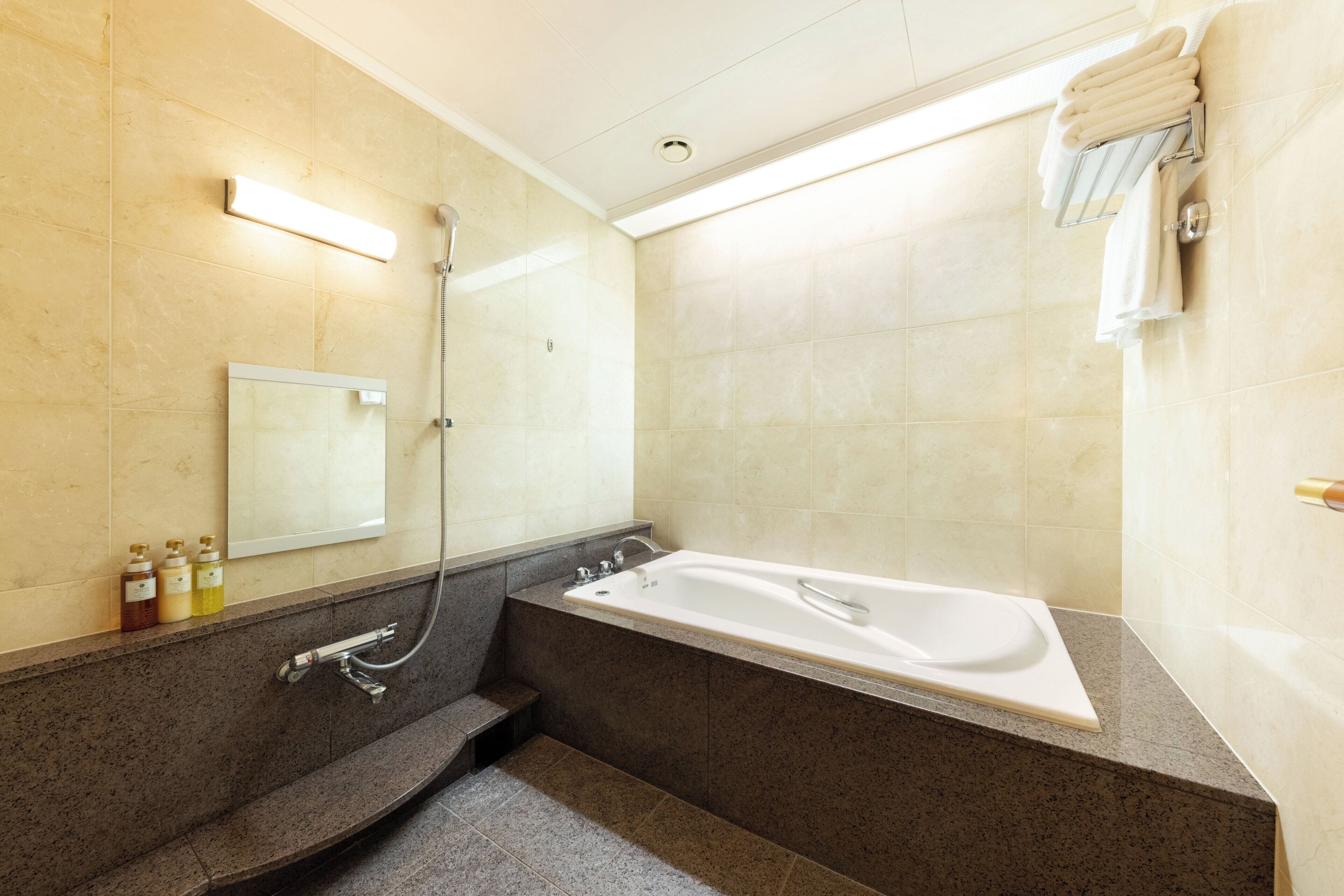 A modern bathroom with a freestanding bathtub, a built-in shower, and a mirror above the sink.
