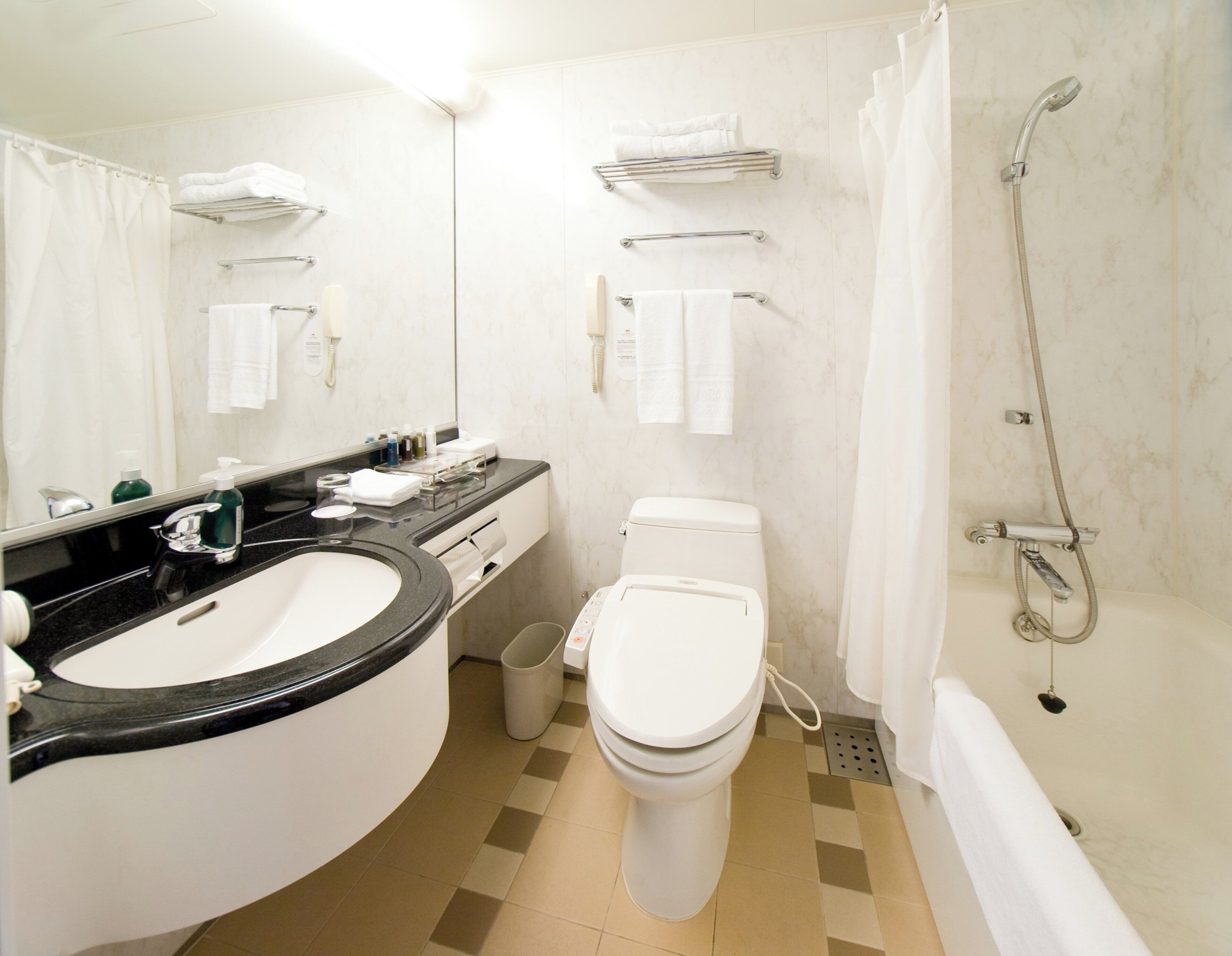 A modern bathroom with a sink, toilet, and shower.
