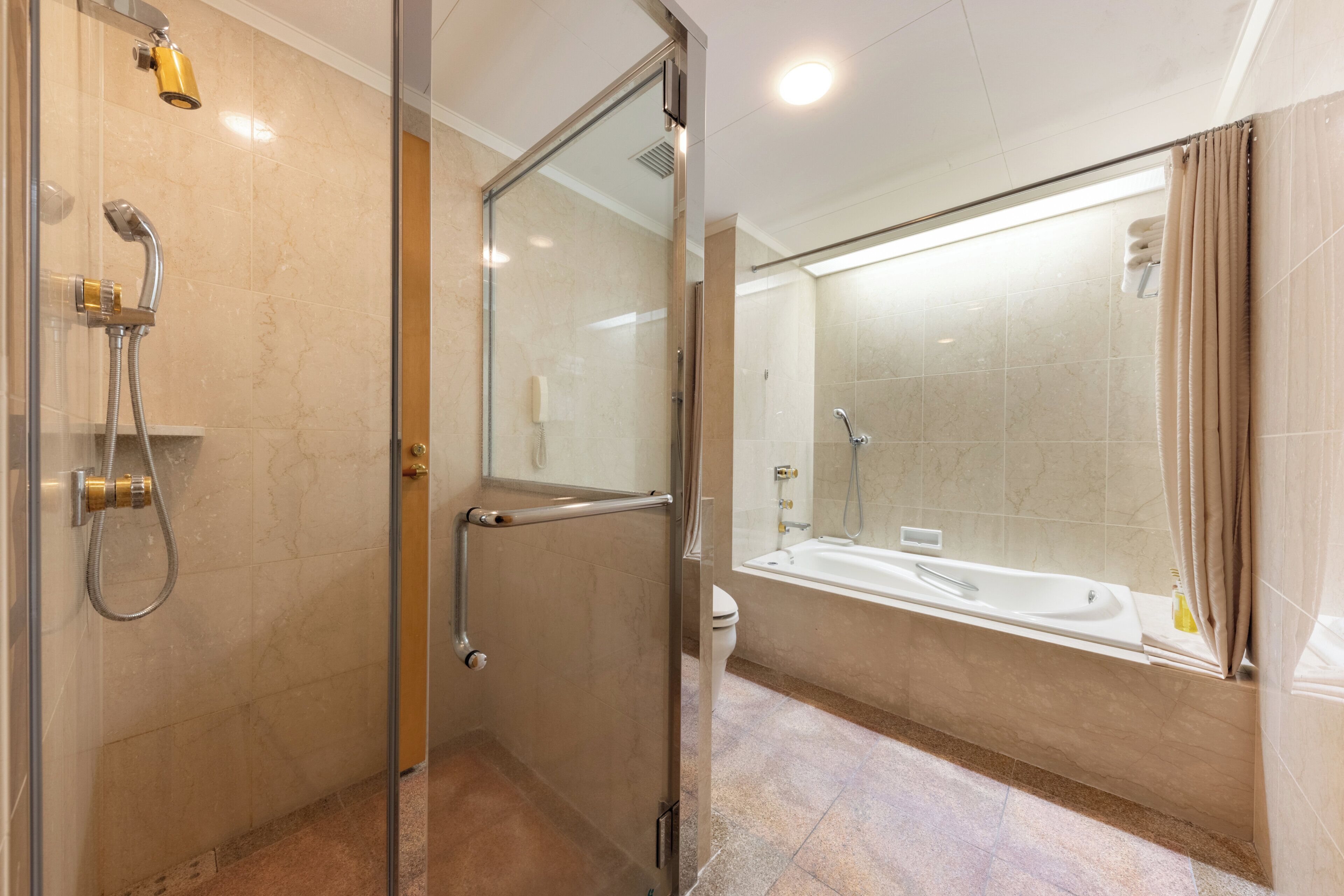 Ein modernes Badezimmer mit einer Glasdusche, einer Badewanne und einem WC.