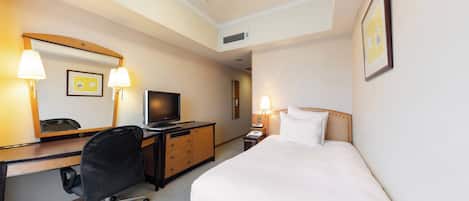 Habitación de hotel con cama, escritorio, silla, televisor y dos lámparas de noche.