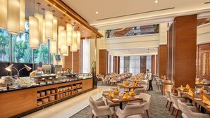 A hotel restaurant with a buffet counter, multiple dining tables, and chairs. - Mardhiyyah Hotel and Suites (Shah Alam)