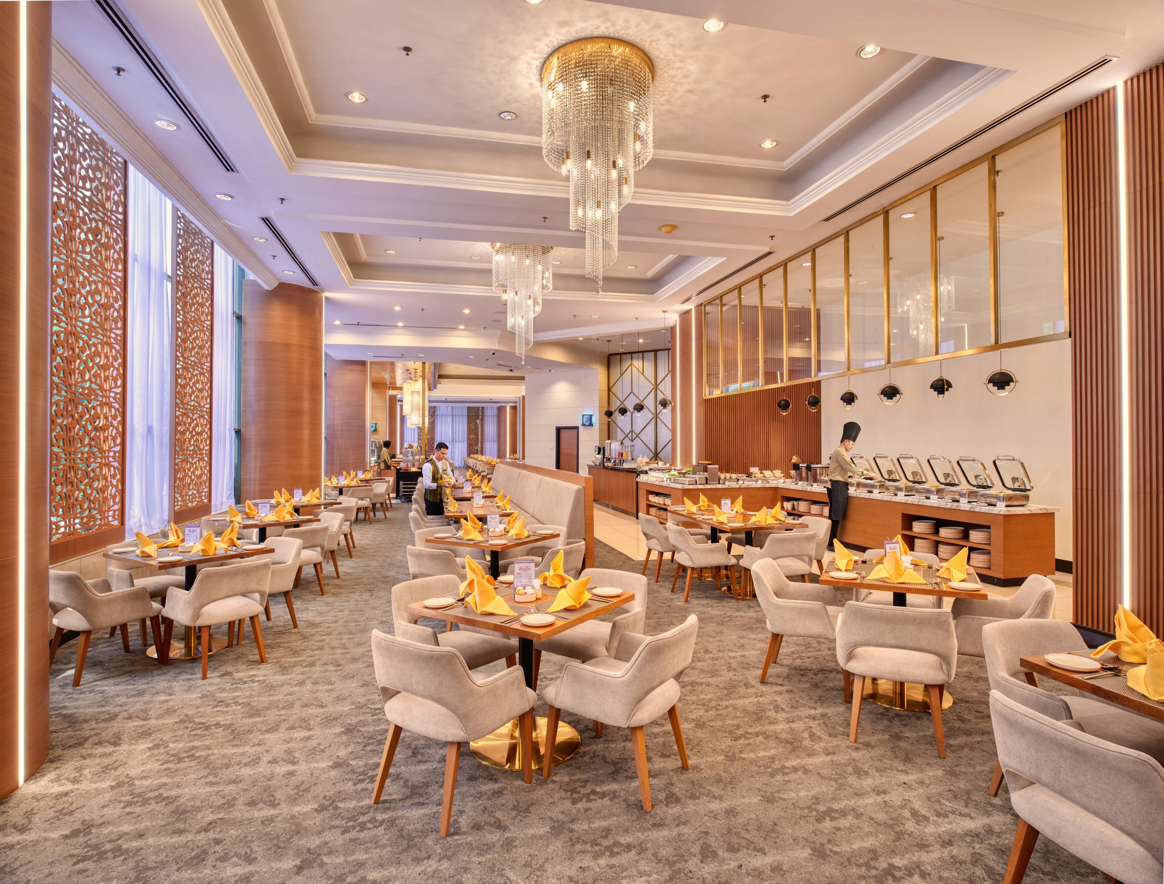 A spacious restaurant with multiple tables and chairs, a buffet area, and a bar.