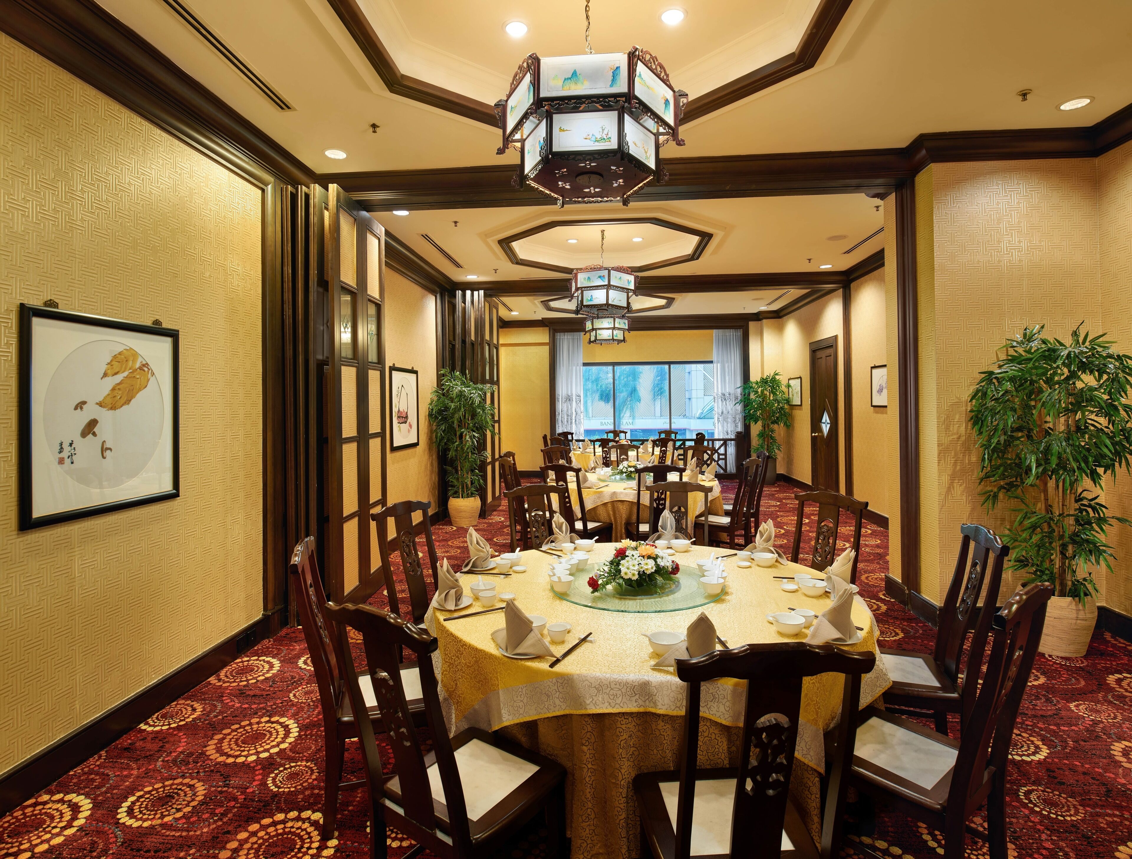 A conference room with round tables, wooden chairs, and a chandelier.