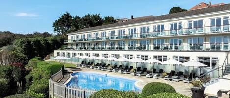 Een seizoensgebonden buitenzwembad en parasols bij het zwembad