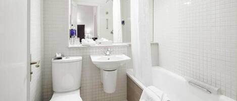 Un baño moderno con inodoro, lavamanos y bañera.