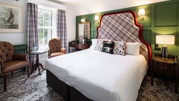 Una habitación de hotel con una cama grande, un escritorio, una silla y una ventana con cortinas.
