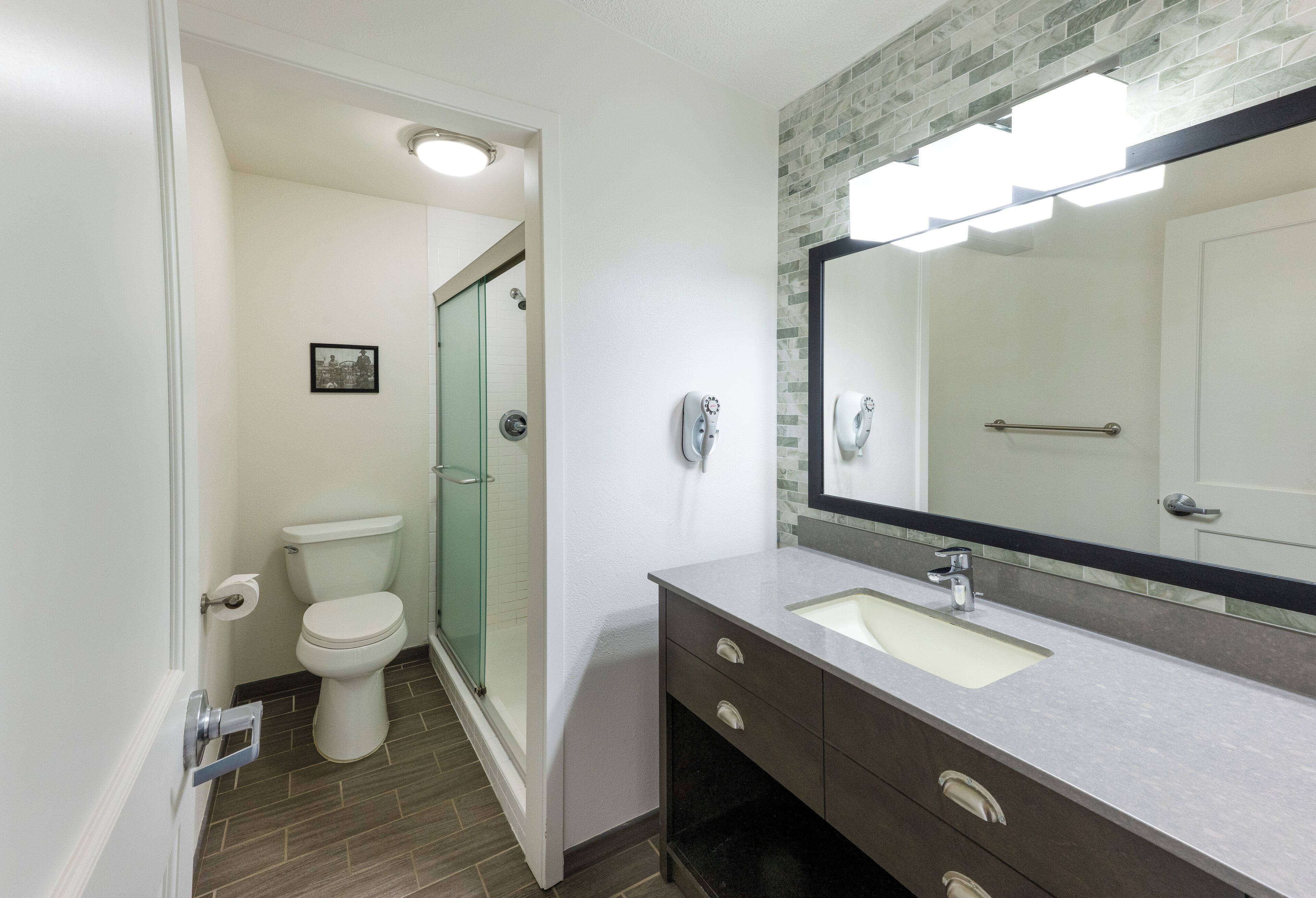 A modern bathroom with a toilet, shower, and sink.