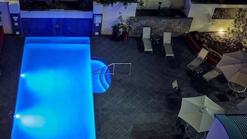 Una piscina al aire libre, sillones reclinables de piscina