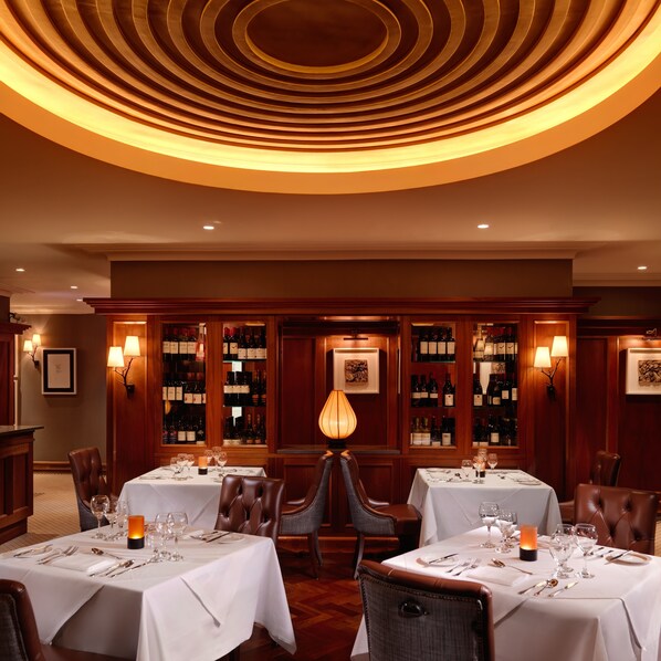 A restaurant with two tables set for dining, each with a white tablecloth and candle centerpieces. - Ballygarry Estate Hotel & Spa (Tralee)