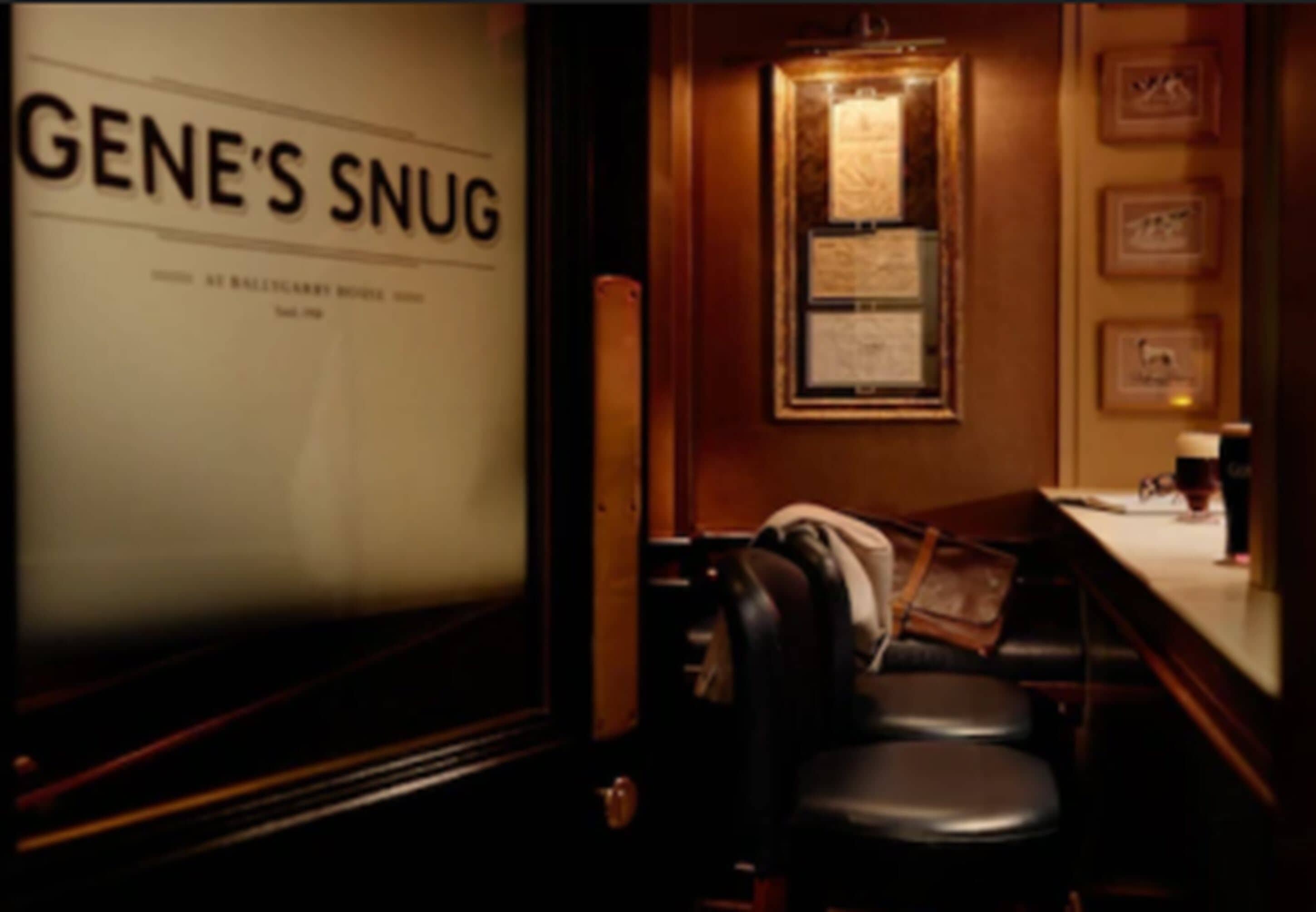 Une pièce faiblement éclairée, avec une enseigne indiquant « GENE'S SNUG », et un coin bar avec des tabourets et un comptoir.