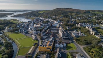 An aerial view of a town with a mix of residential and commercial buildings, a prominent church, and a river.
