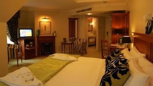 Une chambre d’hôtel équipée d’un lit, d’une télévision, d’une cheminée, d’un bureau et d’une chaise.