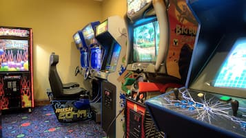 Enjoy a fun gaming experience with arcade machines featuring 'Hot Stuff,' 'Rush 2048,' and 'Big Bang Safari'.