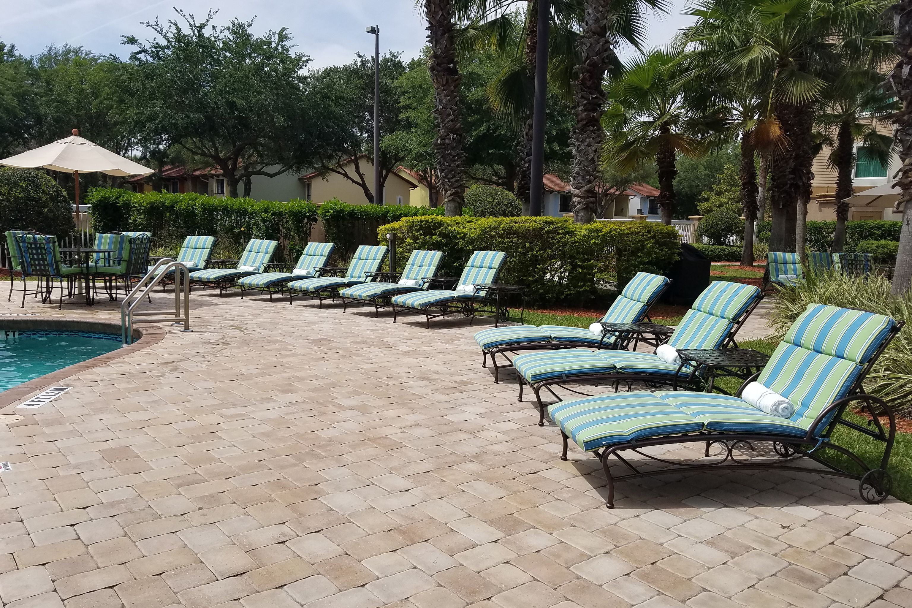 A poolside area with lounge chairs and a pool.