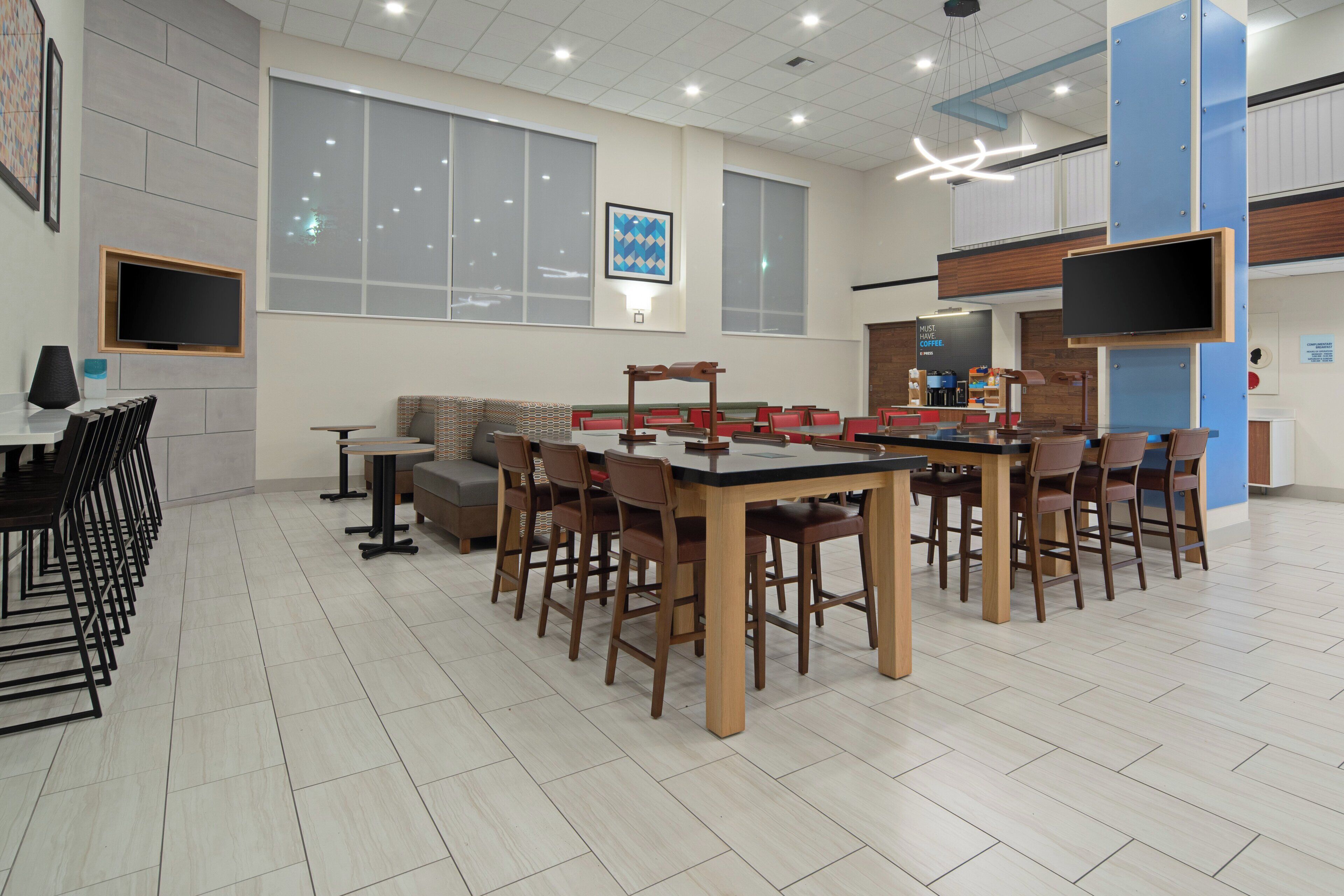 Un espace repas moderne avec une table centrale, plusieurs chaises et un canapé.