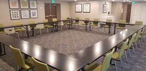 A conference room with a long table, yellow chairs, and framed artwork on the walls. - Holiday Inn Express Hotel & Suites SeaTac by IHG (SeaTac)