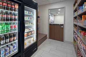 A refrigerated beverage display with various drinks and snacks. - Holiday Inn Express Hotel & Suites SeaTac by IHG (SeaTac)
