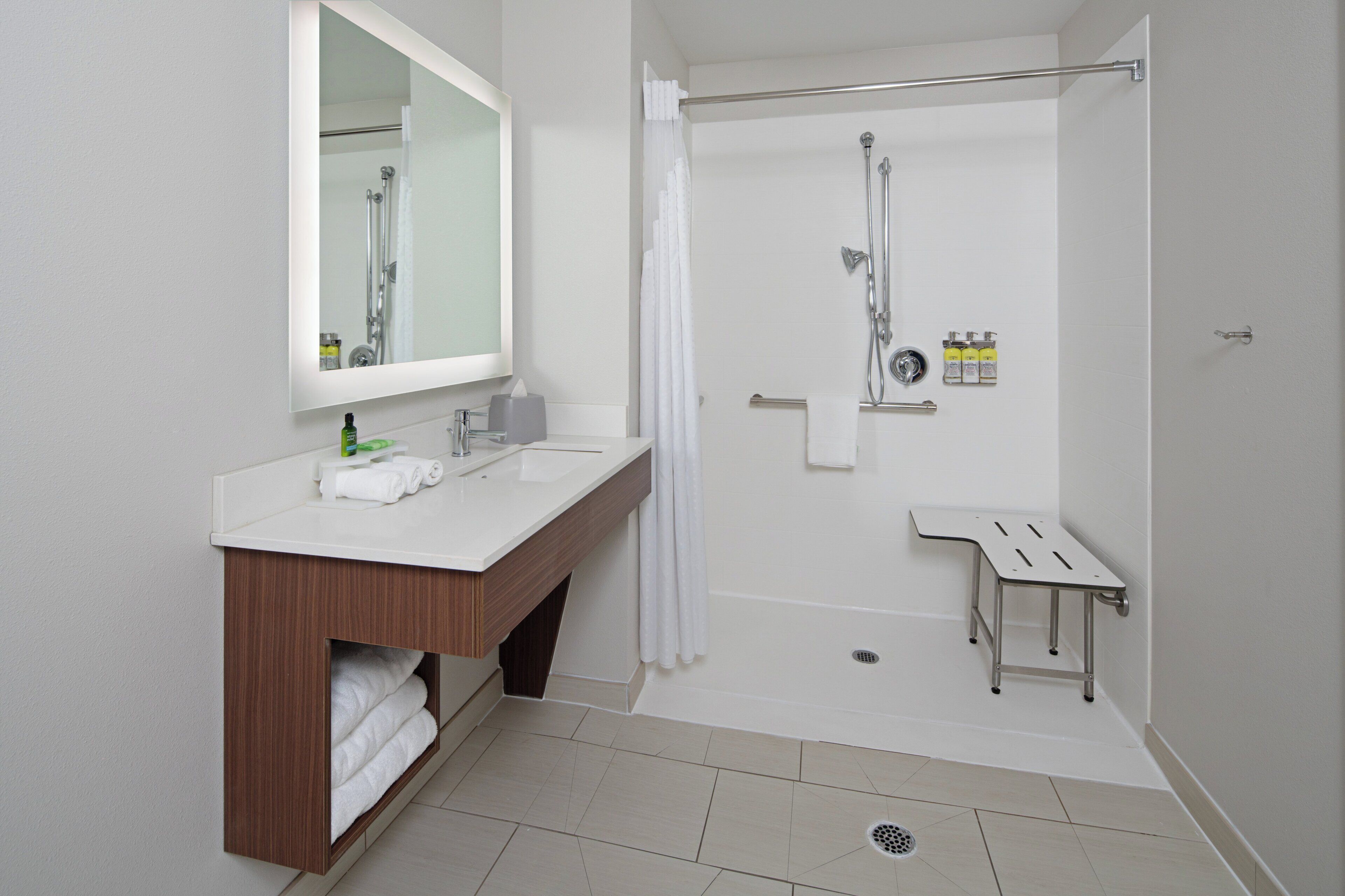 Ein modernes Badezimmer mit Dusche, Waschbecken und Spiegel.
