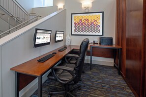 A hotel room with a desk, two monitors, a chair, a telephone, and a framed artwork on the wall. - Holiday Inn Express Hotel & Suites SeaTac by IHG (SeaTac)
