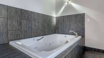 Un baño moderno con una bañera amplia, un mueble de tocador elegante y un diseño contemporáneo.