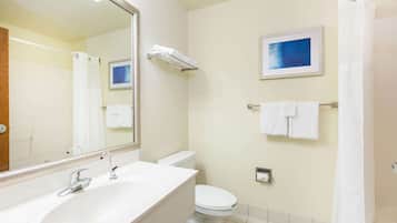 A bathroom with a white sink, a toilet, a towel rack, and a shower curtain.