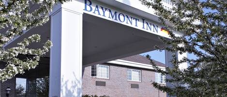 A Baymont Inn building with a white facade, large windows, and a balcony with railings.