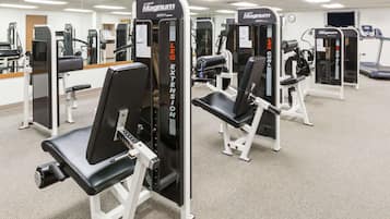 A gym with multiple MAGNUM leg extension machines and treadmills.