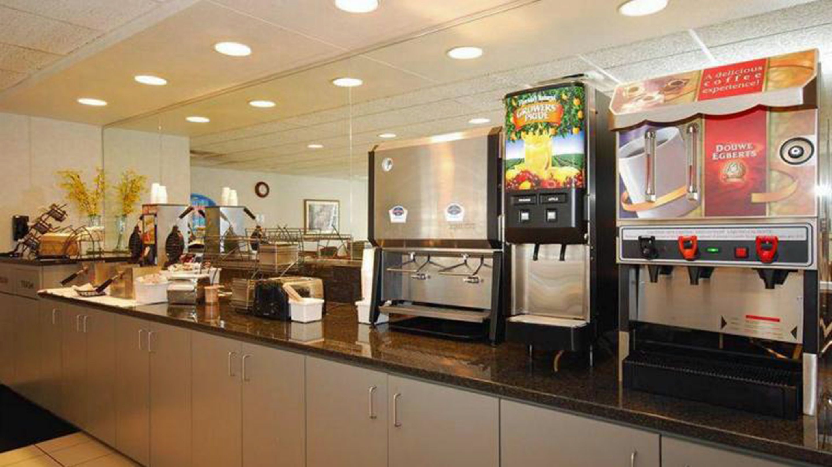 A self-service coffee station with multiple coffee machines and a fruit juice dispenser.