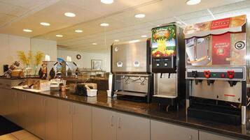 A self-service coffee station with multiple coffee machines and a fruit juice dispenser.