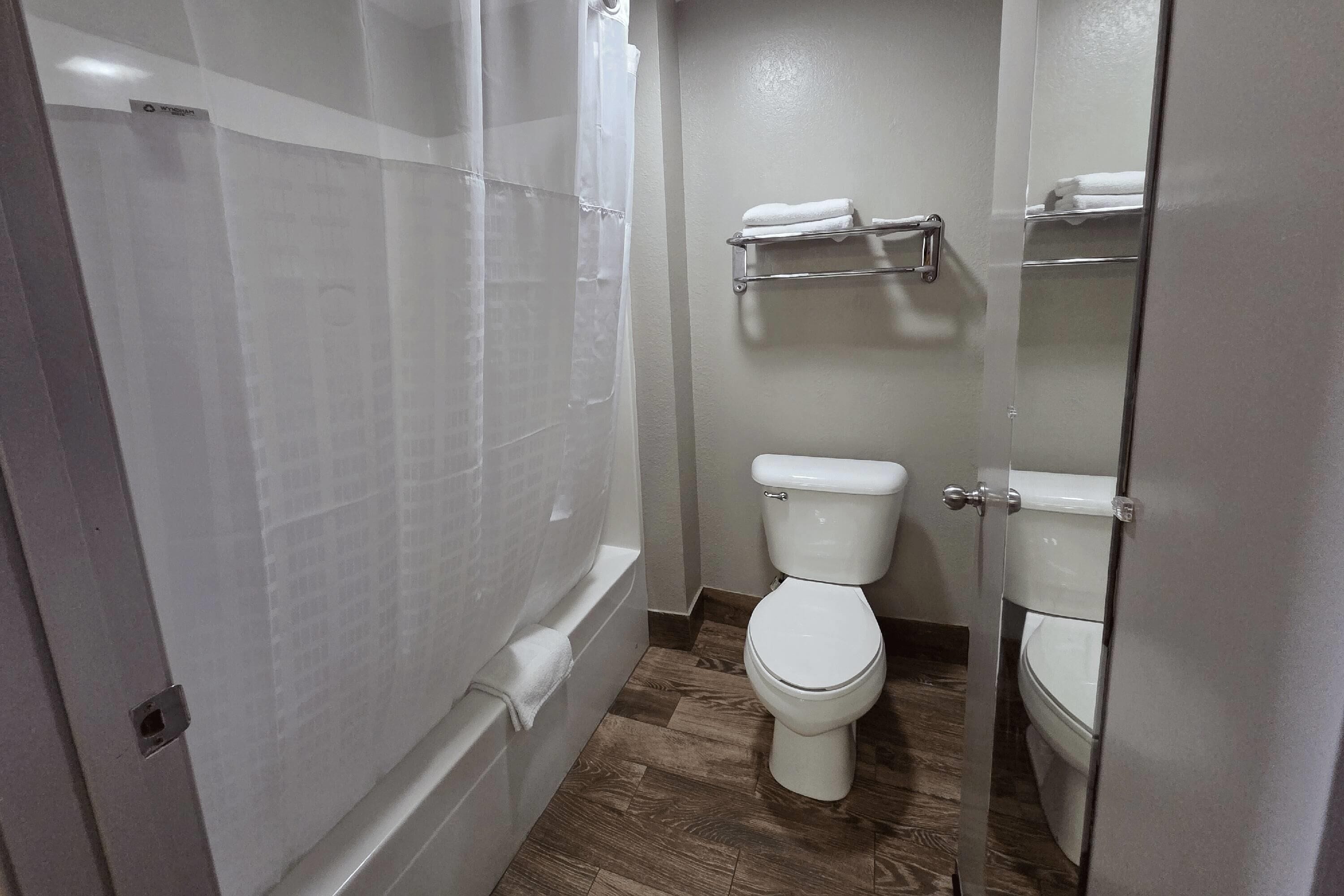 Un baño con inodoro, cabina de ducha y un perchero para toallas.