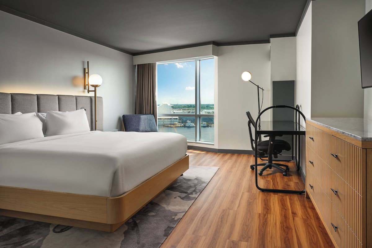 Une chambre d’hôtel moderne avec un grand lit, un bureau et une vue sur la ville.