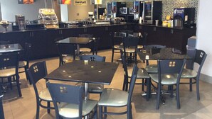 Een modern café met een balie, een zithoek en diverse apparaten.