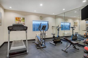 A gym with various exercise equipment, including treadmills, stationary bikes, and weight machines. - Best Western Champions Forest Inn and Suites (Houston)