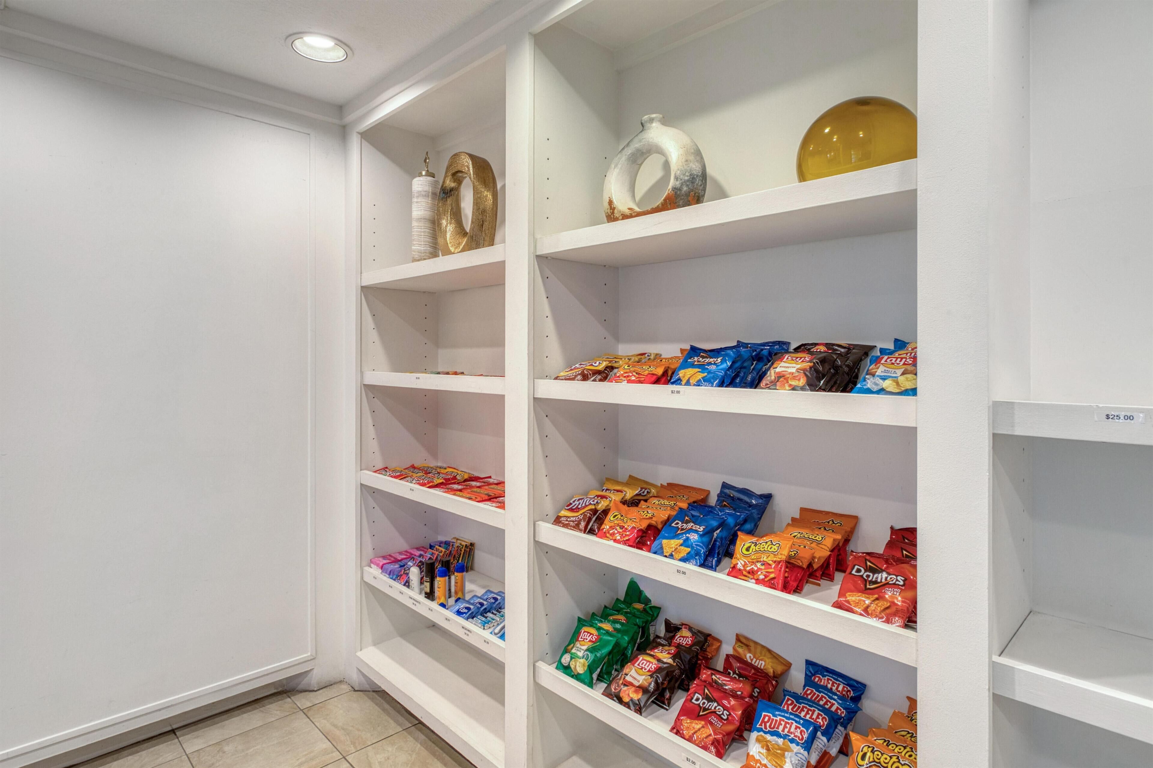 Un garde-manger avec des étagères remplies d’en-cas et de condiments.