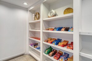 A pantry with shelves stocked with snacks and condiments.