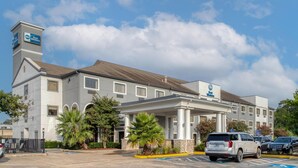 A Best Western hotel with a modern design, featuring a covered entrance and a parking lot with marked handicapped spaces. - Best Western Champions Forest Inn and Suites (Houston)
