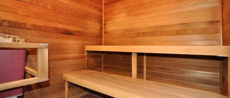 Una sauna con bancos de madera y un banco a la izquierda.