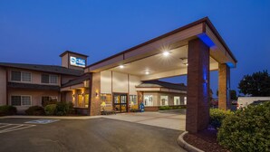 A Best Western hotel with a covered parking area, a ramp for accessibility, and a sign indicating a handicap parking space. - Best Western Rama Inn (Ephrata)