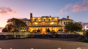 A large, two-story building with a grand entrance, a covered front porch, and a stone wall in front. - The Carrington Hotel (Katoomba)