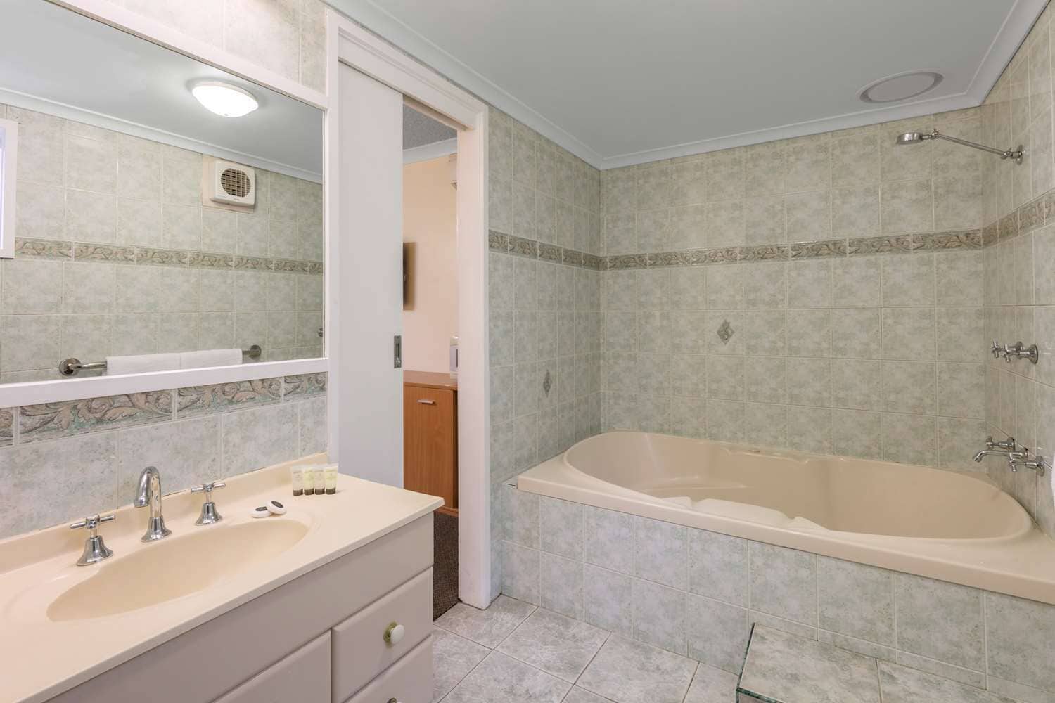 Un baño con lavamanos doble, bañera y ducha.