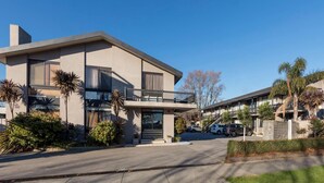 Ein modernes, zweistöckiges Gebäude mit flachem Dach, großen Fenstern und einem Balkon.