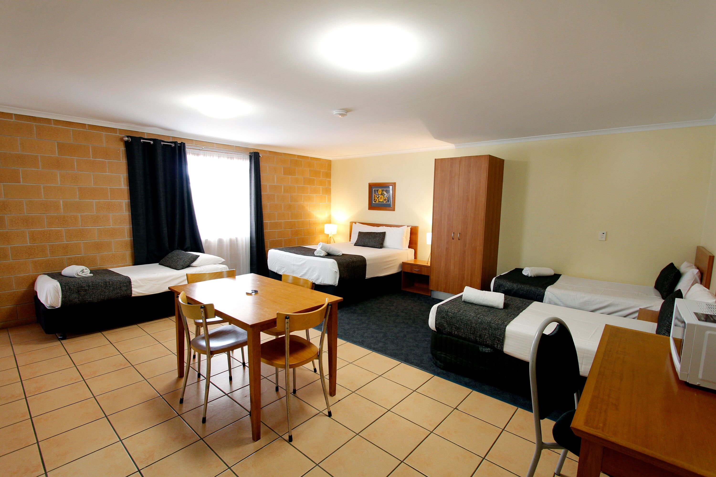 Une chambre d’hôtel avec deux lits simples, une table en bois et une chaise.