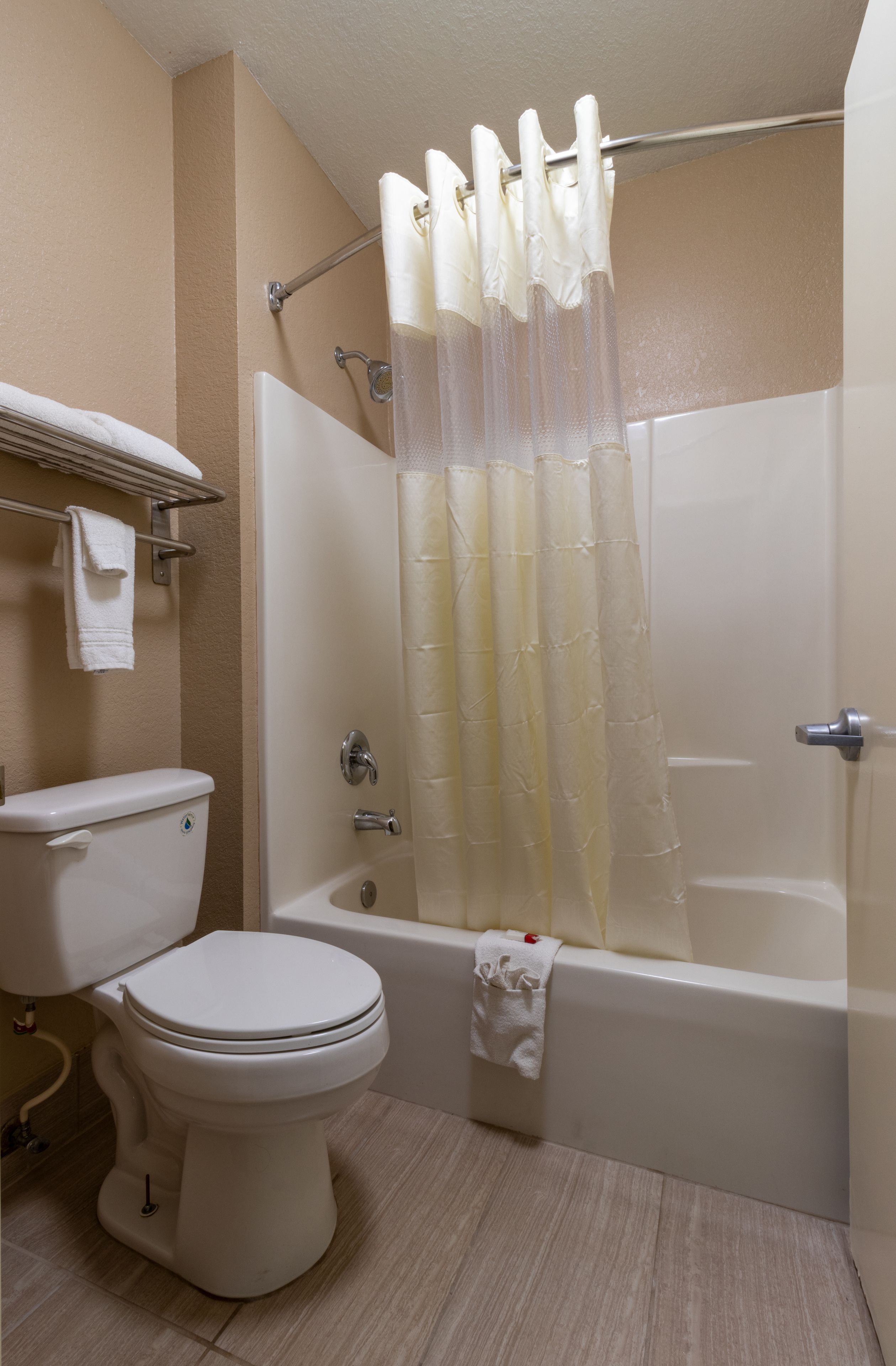 A bathroom with a toilet, bathtub, and shower curtain.