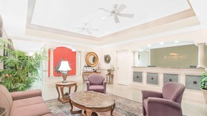 A hotel lobby with a reception desk, seating area, and decorative elements. - Baymont by Wyndham Crestview (Crestview)