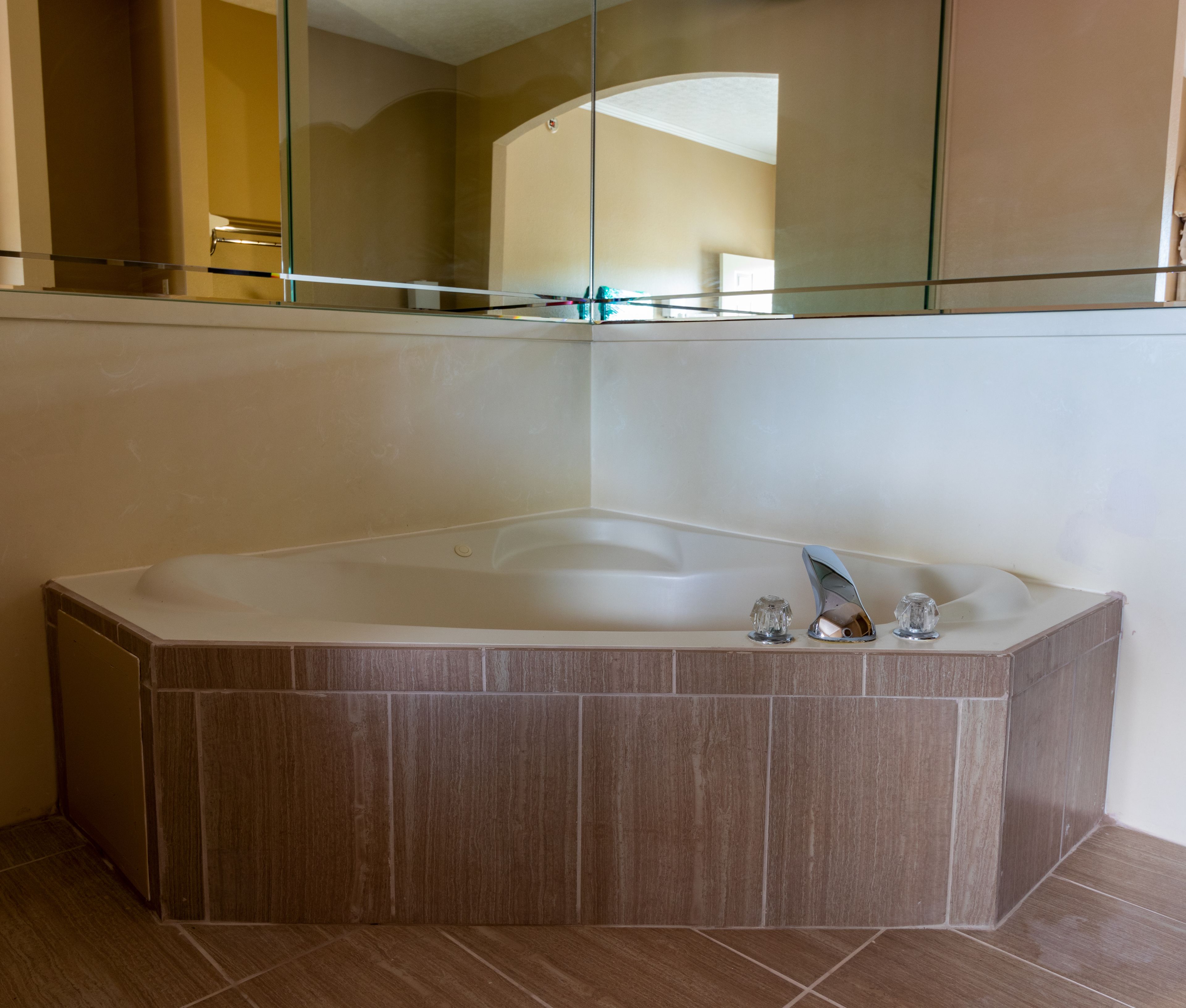 A modern bathroom with a freestanding bathtub, a glass shower enclosure, and a large mirror above the tub.