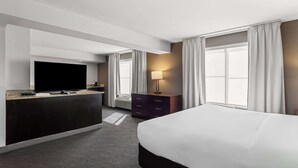 A hotel room with a bed, a TV, a desk with a lamp, and a window with curtains. - Comfort Inn & Suites near Tinley Park Amphitheater (Tinley Park)
